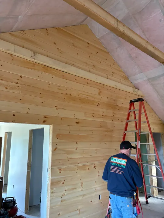 Finished pine wall running up to an insulated vaulted ceiling