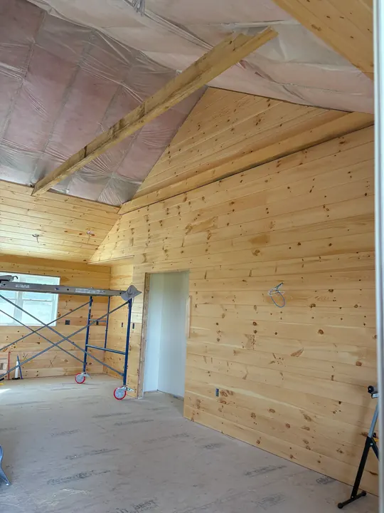Tall gable wall fully paneled in pine from floor to peak
