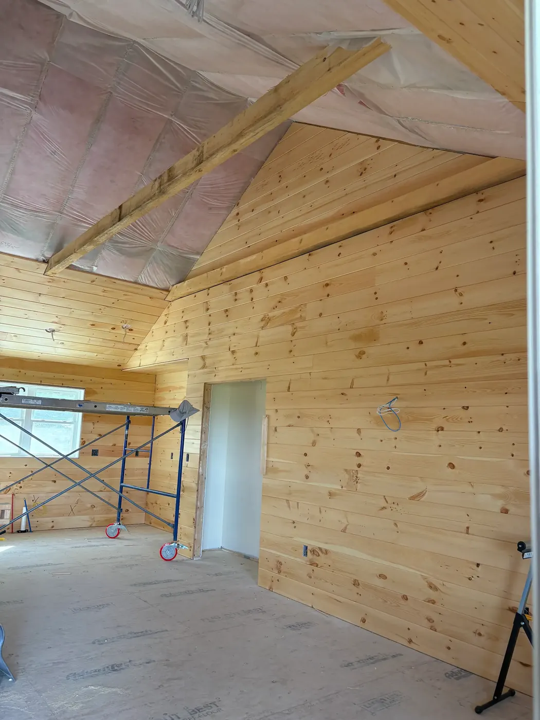Tall gable wall paneled in pine from floor to peak