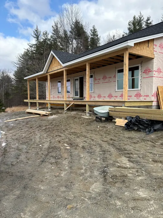 Wide view of a new covered porch running across the front of a house