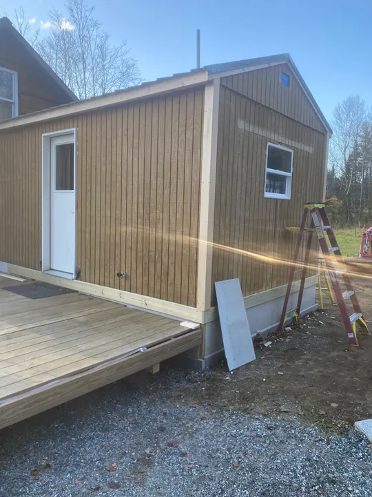 Backyard shed with worn vertical board siding